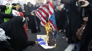 Iranian female demonstrators burn a representation of the US flag and a caricature of President Barack Obama in an annual state-backed rally in front of the former US Embassy in Tehran, Iran, in November 2012. (photo credit: AP/Vahid Salemi/File)